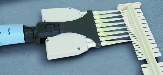 Multichannel pipette aligned with an included mini-system comb; demonstration pipette not included